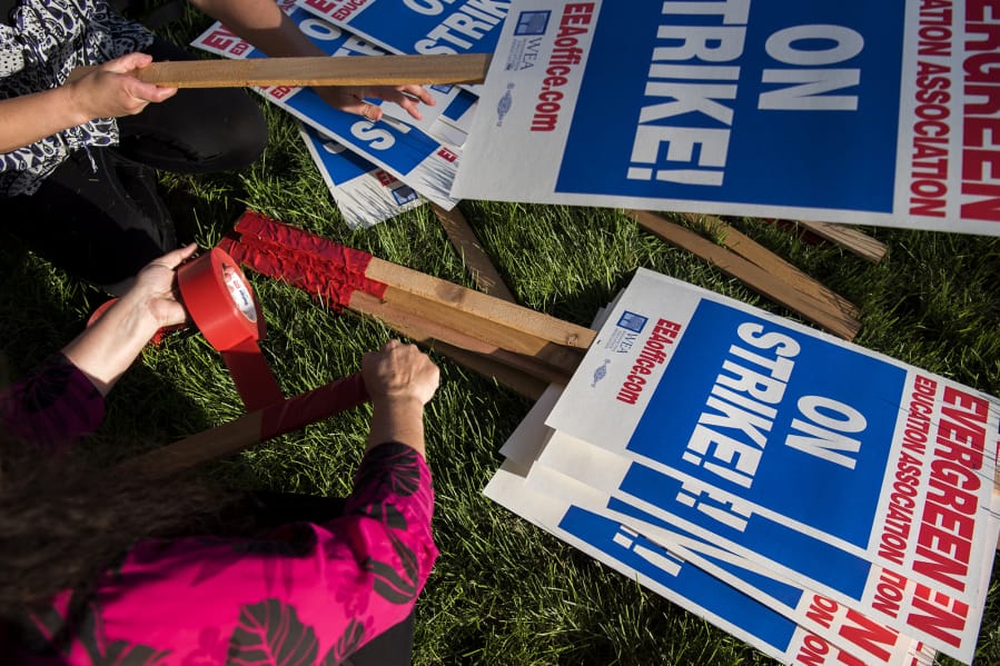 Teachers make signs Thursday after the Evergreen Education Association general membership meeting, where members voted in favor of a strike.