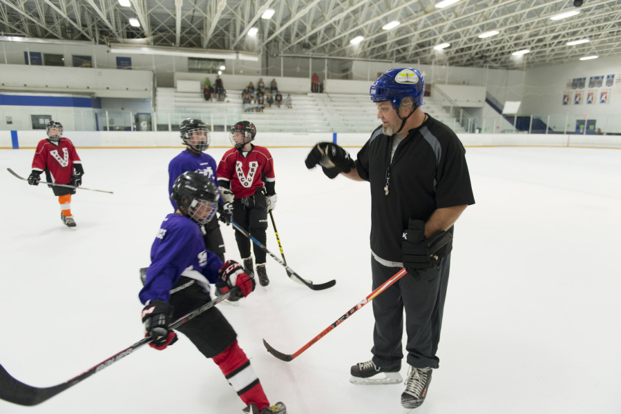 Mike Gamby congratulates Landon Wells for scoring Sunday afternoon during a pickup youth hockey game at Mountain View Ice Arena. Gamby helped organize the informal summertime games so local youth hockey players can play for fun, outside of usual league practices and games.