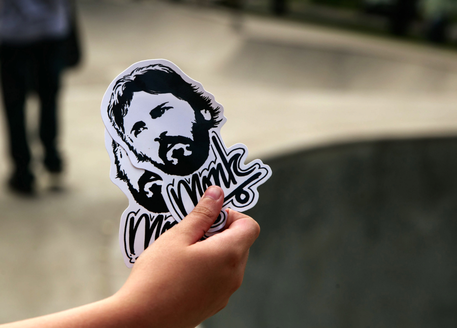 Stickers honoring Mark “Monk” Hubbard are given out June 22 at the Delridge Skatepark.