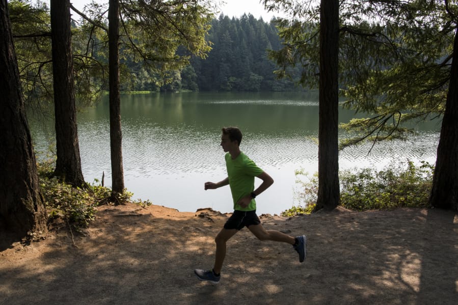 Washougal senior Gabriel Dinnel, here running by Round Lake in Camas, loves the variety of courses and challenges that cross country offers.