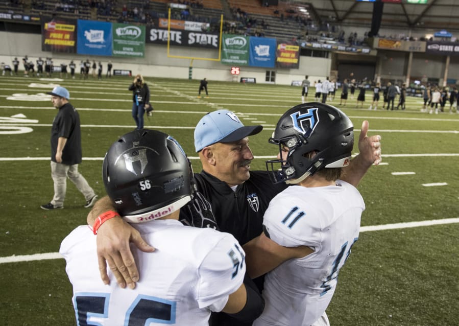 Hockinson head coach Rick Steele congratulates Robert Flores (56) and Sawyer Racanelli (11) after winning the 2A state football championship game against Tumwater on Saturday, Dec. 2, 2017, in Tacoma, Wash. Hockinson defeated Tumwater 35-22 to win their first state title.