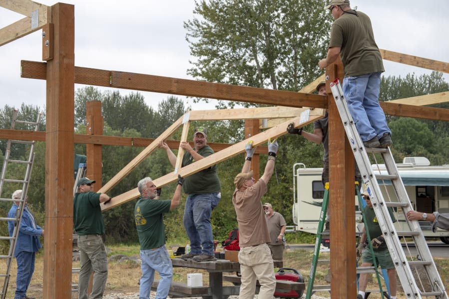 Volunteers from the Vancouver Wildlife League set the trusses for the roof of the ADA accessible shooting pavilion recently built at the Vancouver Lake trap shooting range.