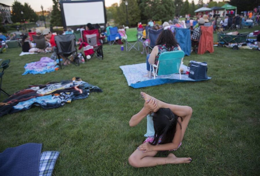 Mariella Bibian, 9, of Vancouver shows her flexibility while waiting with the crowd for the start of the movie “Wonder Woman” at Columbia Tech Center Park on July 27, 2018. The film, which was freec, is part of the Movies in the Park series hosted by the city of Vancouver.