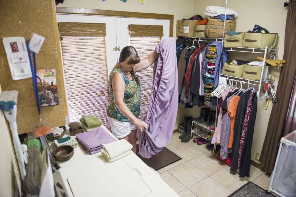 Andi Crockford folds laundry while preparing her apartment for its next guest.