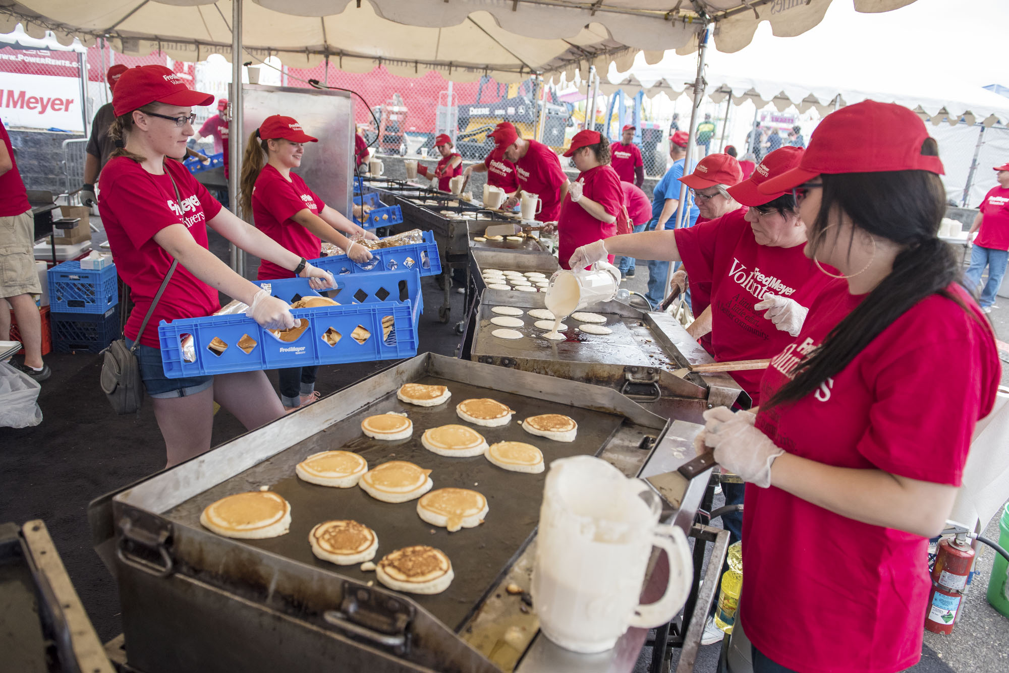 The cooking line prepares batches of pancakes before for the the Fred Meyer Free Pancake Breakfast at the Clark County Fair on Friday morning, Aug. 3, 2018.