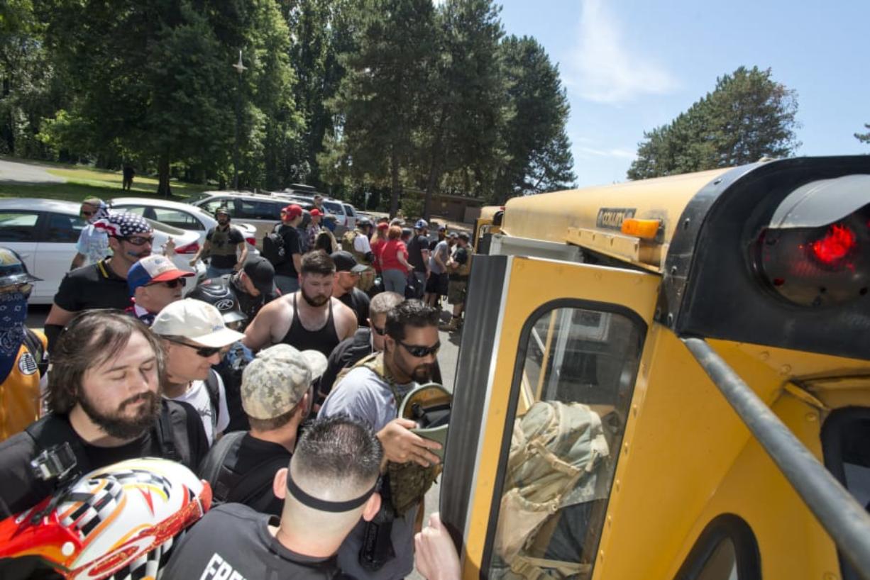 Patriot Prayer supporters board a bus Saturday at Marine Park in Vancouver for the trip to downtown Portland to attend a rally.