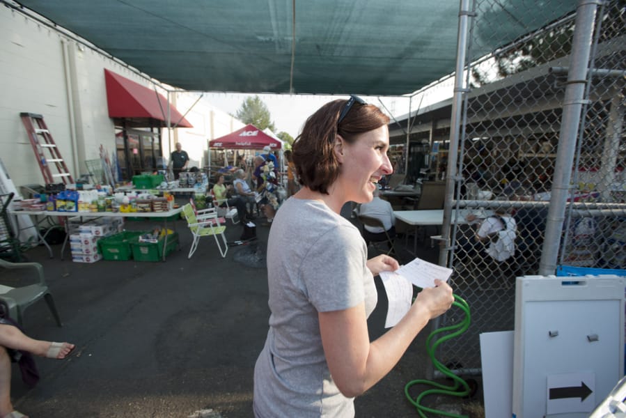Maureen Montague, executive director of Columbia Springs Environmental Education Center, calls out for the next hopeful owner of a busted something-or-other to present it to a skilled volunteer at the Aug. 9 Repair Cafe hosted by Ace Hardware in Hazel Dell.