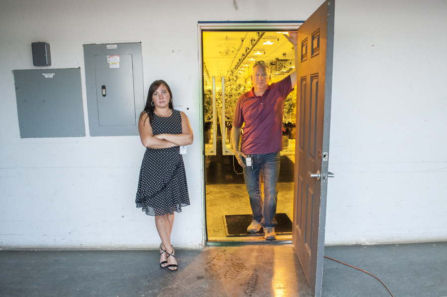 Tracy and Ty Camp pose at the entrance to the grow room at Sunshine Farms. Ty Camp owns the business, but Tracy Camp ultimately lost her banking job as a result.
