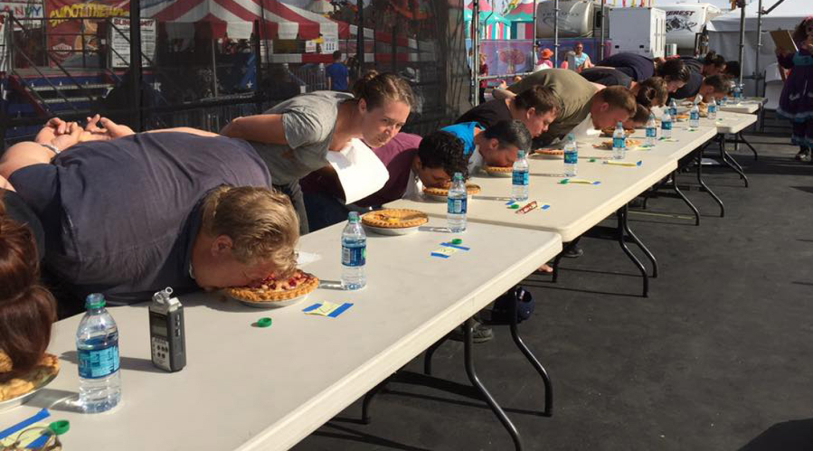 Eager eaters in the 2017 pie-eating contest tackle their challenge.