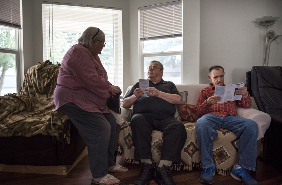 Ombudsman Joan McConnell, from left, Wilfred Lirette Jr. and Henry Cayton speak about the ombudsman program at an adult family home in Vancouver. McConnell started volunteering with the program about a decade ago. The program is in need of more volunteers.