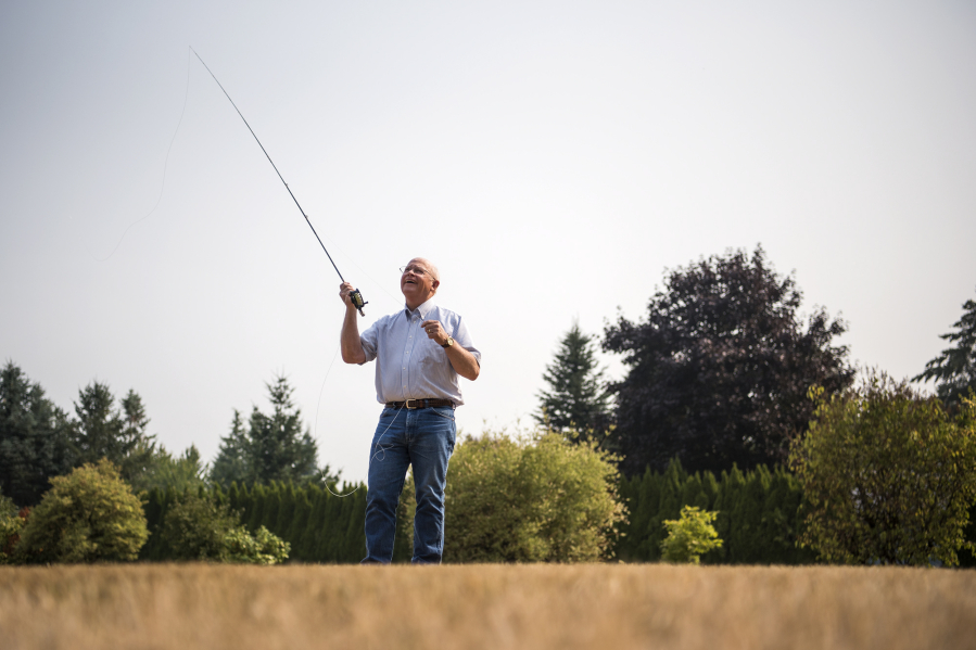 Mike McCoy, owner of Snake Brand Products, demonstrates fly-casting techniques on the lawn outside his workshop. McCoy makes a patented line guide for fly rods that enables fishers to cast farther and more accurately.