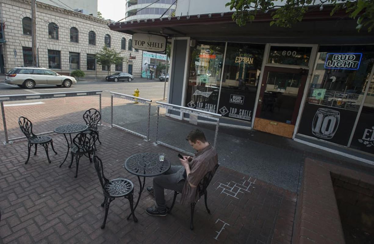 Vancouver resident Sheldon Gustafson relaxes with an after-work drink in the outdoor seating area at Top Shelf Martinis on Main. Negotiations led the restaurant to change its patio to satisfy state and local regulations, setting a precedent for other businesses statewide.