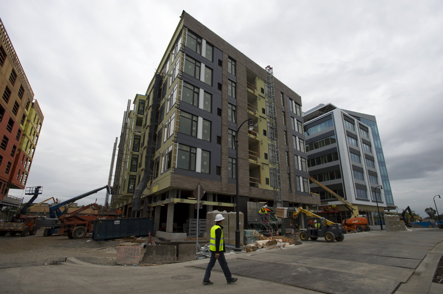 Construction continues along The Waterfront Vancouver as the Rediviva apartment complex, center, takes shape Friday morning. Although the complex isn’t ready for tenants yet, about 10 percent of its units have been pre-leased.