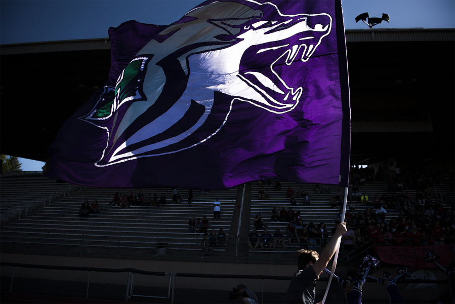 A Heritage cheerleader runs the flag up feild following a Heritage touchdown in the first quarter against Evergreen at McKenzie Stadium on Friday night, Aug. 31, 2018.