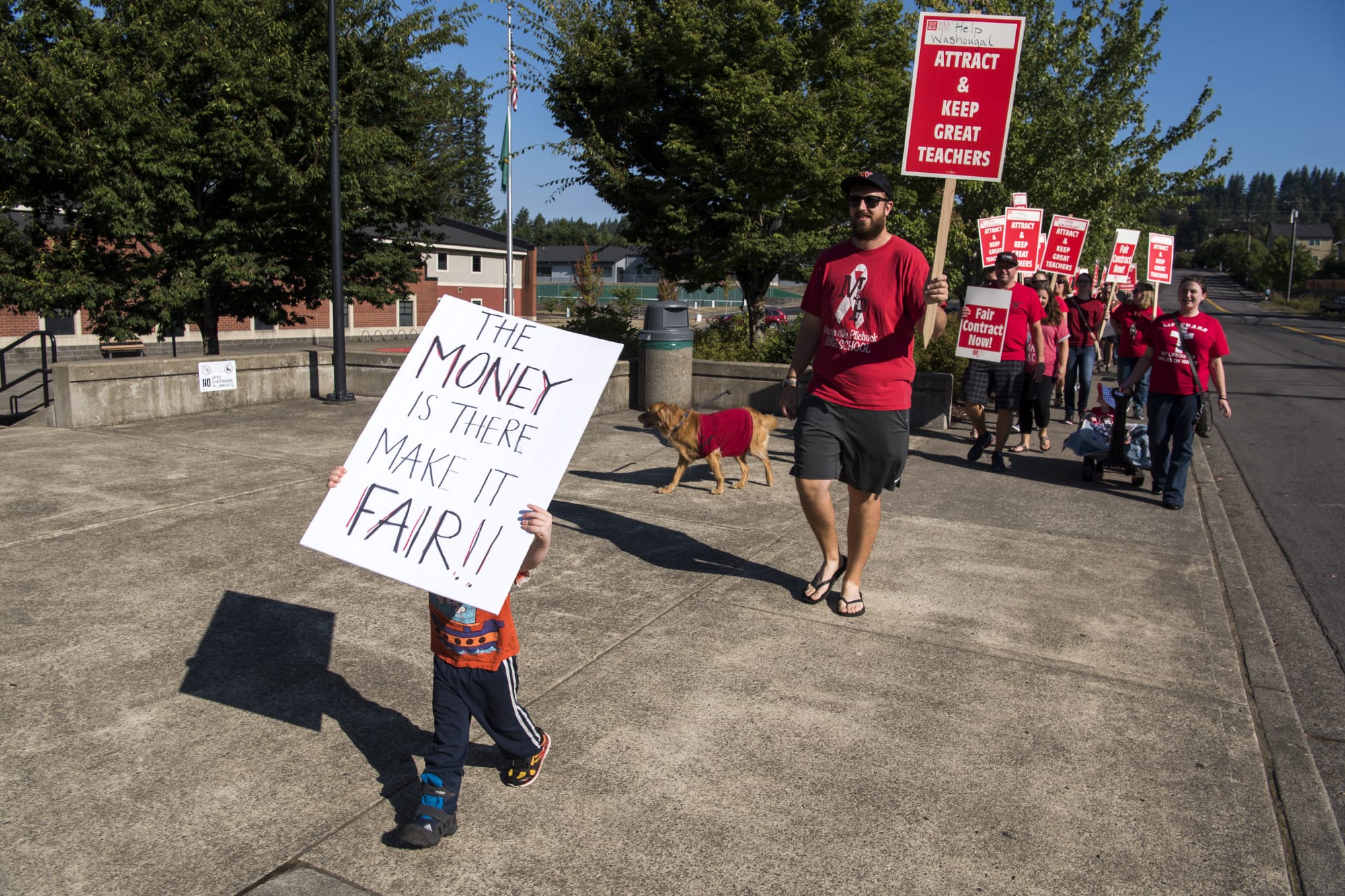 Timothy Tauscher of Washoughal, 3, marches in front of the teachers outside Washougal High School during the first day of the strike on Tuesday, Aug. 28, 2018. Tauscher's grandmother is a teacher at the school so his mother, Ellie, brought him out to help support her and the other teachers.