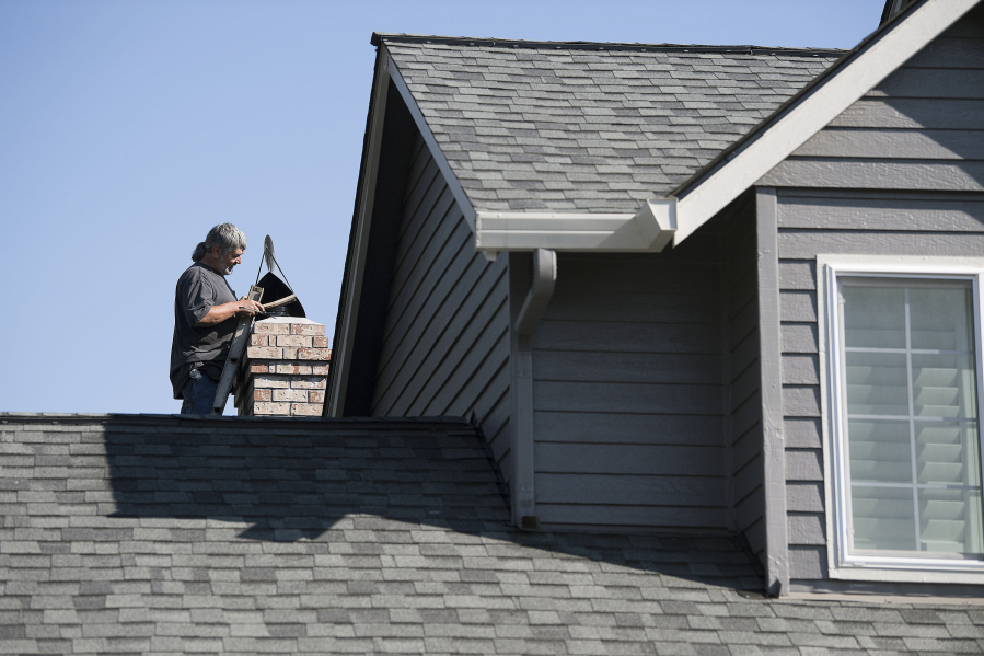 Dan Dilley, a chimney sweeper and owner of “A” Your Town Chimney, checks a chimney atop a customer’s home Tuesday in Camas. He has been sweeping chimneys for more than 30 years and has owned his Washougal business since 1996.