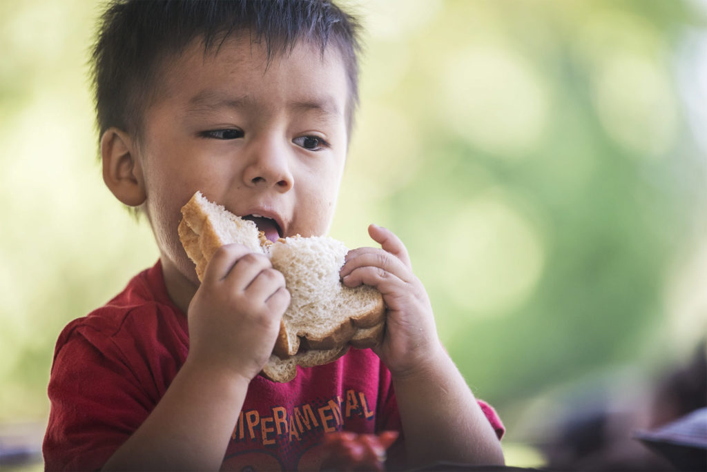 Image result for kid eating peanut butter and jelly sandwich