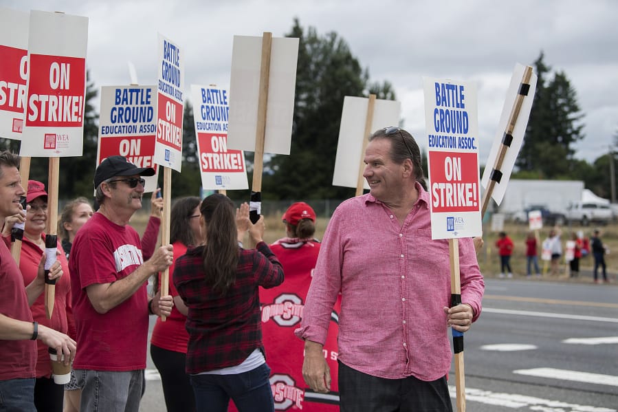 Summit View High School teacher Stewart Demos, right, chats with fellow educators as they greet motorists along Lewisville Highway while on strike Thursday morning. Demos has been a teacher for 20 years, and said he’s frustrated by the ongoing negotiations. “It’s just shady,” he said.