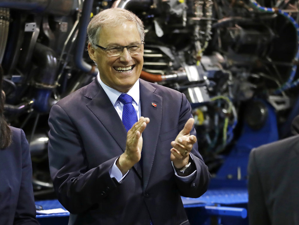In this June 6, 2018 photo, Washington Gov. Jay Inslee applauds as he waits to speak at South Seattle College in Seattle during a news conference. Inslee, a two-term Democratic governor and former congressman, is likely best known outside the state for his focus on climate issues and renewable energy, but lately he's getting notice for a different role: an adversary to President Donald Trump. And while he's aware of the 2020 presidential chatter that includes his name, Inslee steers conversations on that topic to other elections. (AP Photo/Ted S.