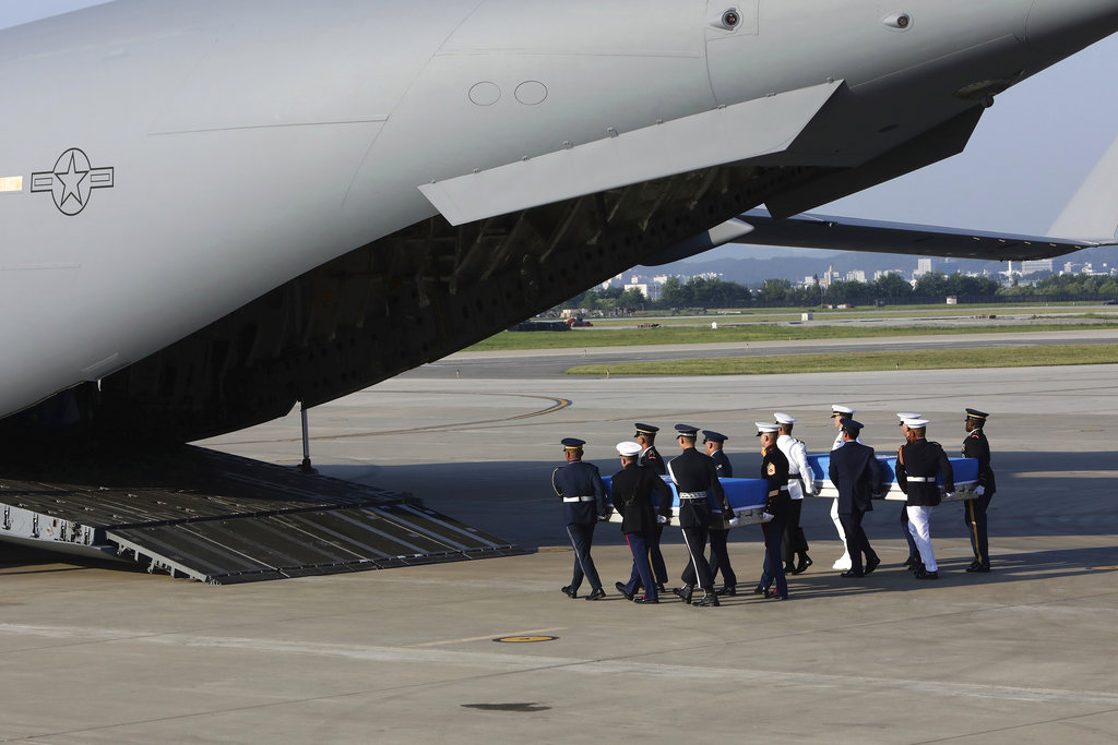 U.N. honor guards carry the remains of U.S. servicemen killed in the Korean War and collected in North Korea, onto an aircraft at the Osan Air Base in Pyeongtaek, South Korea, Wednesday, Aug. 1, 2018. North Korea handed over 55 boxes of the remains last week as part of agreements reached during a historic June summit between its leader Kim Jong Un and U.S. President Donald Trump.