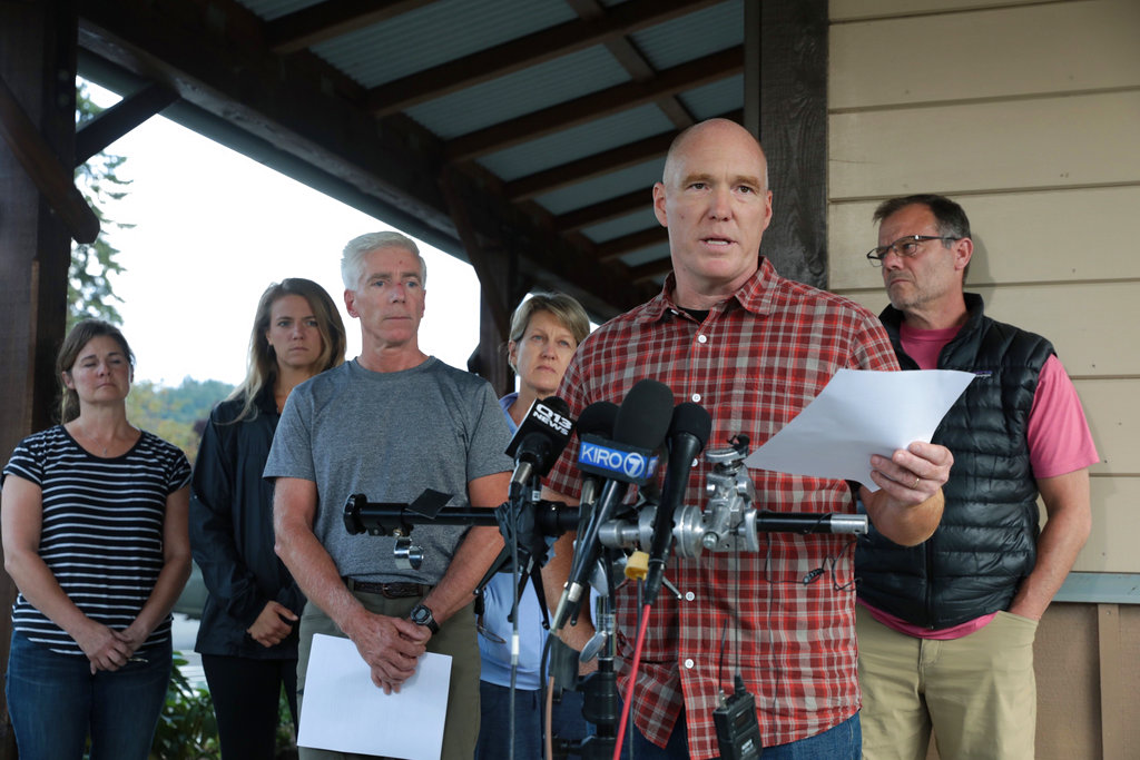 Mike Mathews and friends of Richard Russell talk to the media Saturday, Aug. 11, 2018, at the Orting Valley Police and Fire Department, in Orting, Wash. Russell is presumed dead after stealing a plane from SeaTac International Airport and crashing it into Ketron Island Friday, Aug. 10.