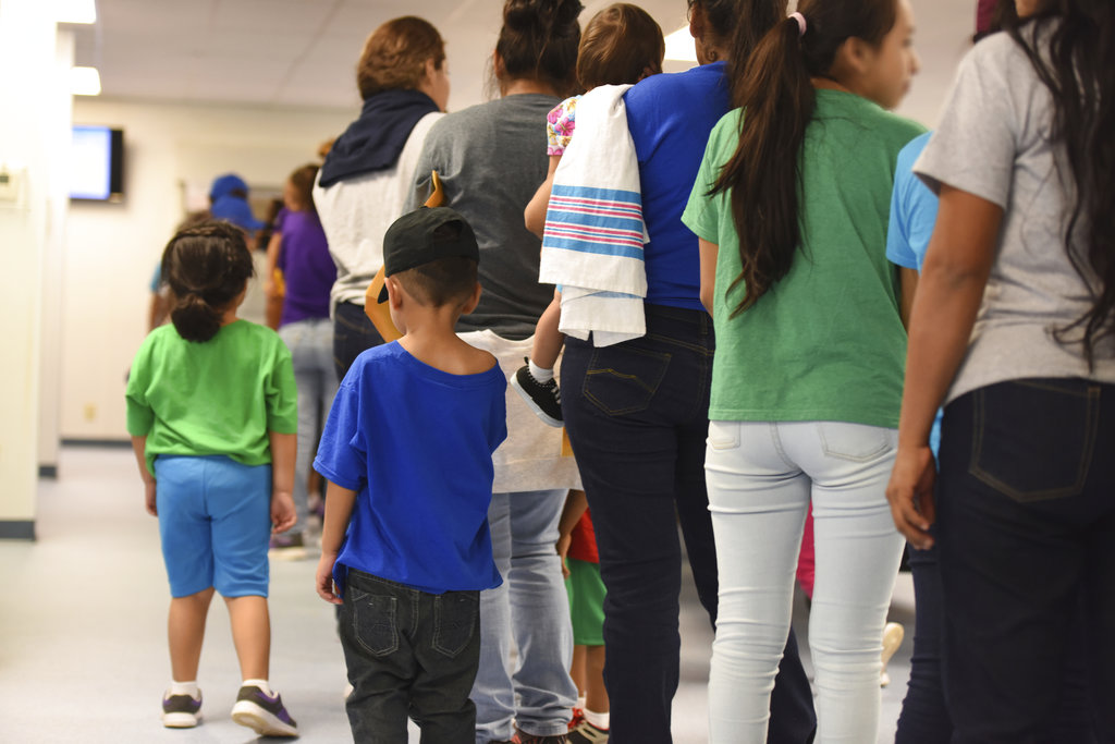 FILE - In this Aug. 9, 2018, file photo, provided by U.S. Immigration and Customs Enforcement, mothers and their children stand in line at South Texas Family Residential Center in Dilley, Texas. A complaint expected to be filed Thursday, Aug. 23 with the Department of Homeland Security alleges that immigration authorities coerced dozens of parents separated from their children at the border to sign documents they didn't understand. In some of those cases, parents gave away rights to be reunited with their kids. The complaint will be filed by the American Immigration Lawyers Association and the American Immigration Council. (Charles Reed/U.S.