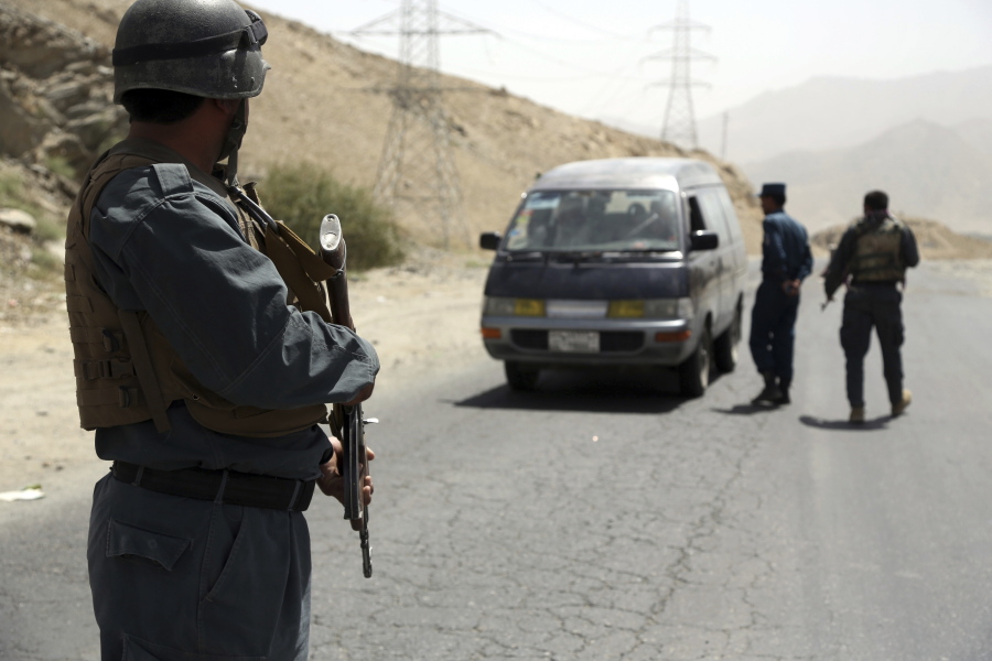 Afghan police officers search a vehicle at a checkpoint on the Ghazni highway west of Kabul, Afghanistan, Monday, Aug. 13, 2018. Afghan Defense Minister Gen. Tareq Shah Bahrami said Monday that about 100 policemen and soldiers as well as 20 civilians have been killed in past four days of battle in the eastern capital of Ghazni.