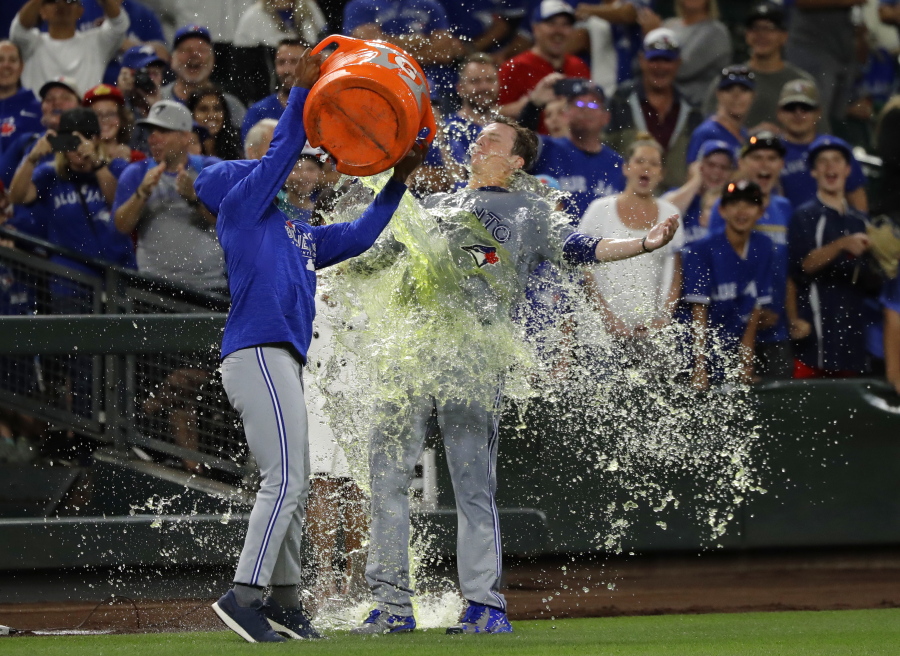 Toronto Blue Jays winning pitcher Ryan Borucki, right, is doused after the Blue Jays defeated the Seattle Mariners 7-2 in a baseball game Friday, Aug. 3, 2018, in Seattle. (AP Photo/Ted S.