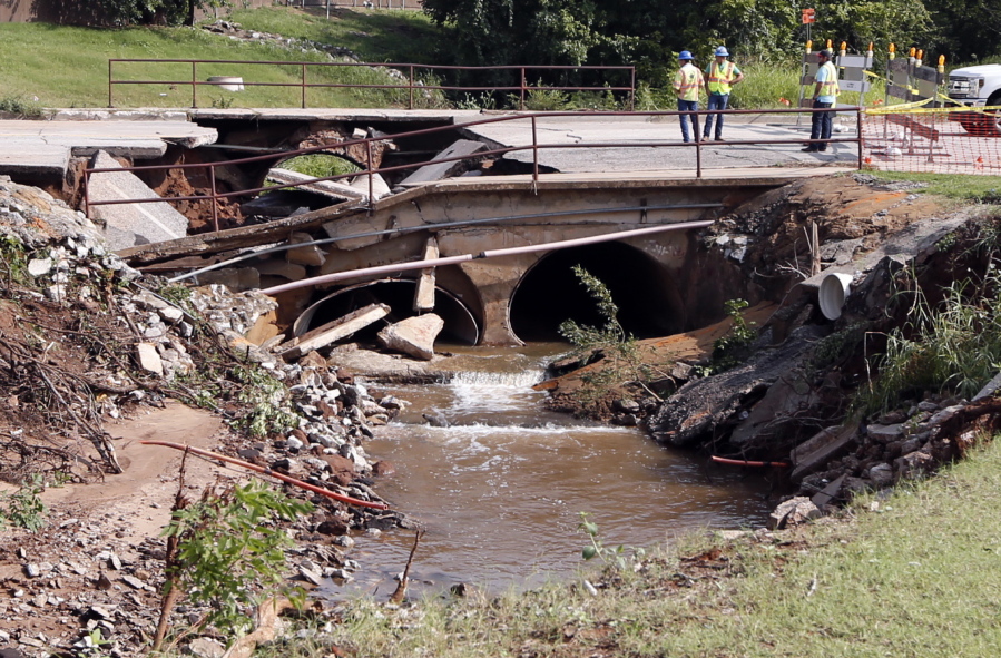 Engineers and workers survey a bridge Wednesday that collapsed due to rains Tuesday in Norman, Okla.