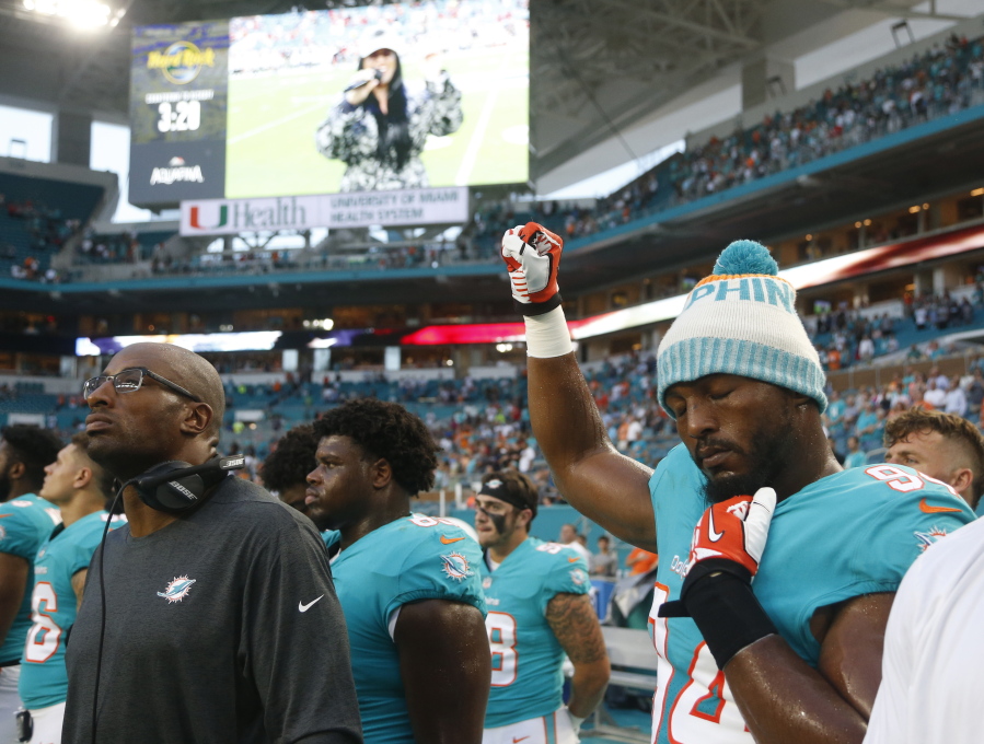 Miami Dolphins defensive end Robert Quinn (94) raises his right fist during the singing of the national anthem, before the team’s NFL preseason football game against the Tampa Bay Buccaneers on Thursday in Miami Gardens, Fla.