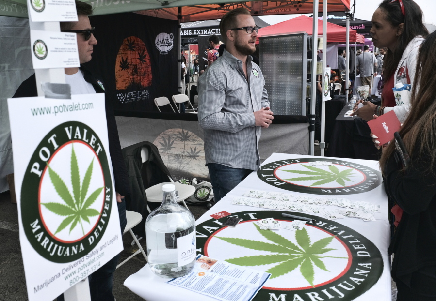 FILE - This March 31, 2018 photo shows a booth advertising a delivery service for cannabis at the Four Twenty Games in Santa Monica, Calif. Police chiefs and cities are working together to block a proposed state rule that they say would allow unchecked home marijuana deliveries anywhere in California, even into places that have banned cannabis sales. California Police Chiefs Association President David Swing says in a statement that the change would “open the floodgates” for potential criminal activity.