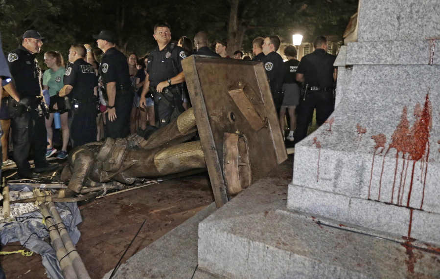 Police stand guard after the confederate statue known as Silent Sam was toppled by protesters on campus at the University of North Carolina in Chapel Hill, N.C., on Monday.