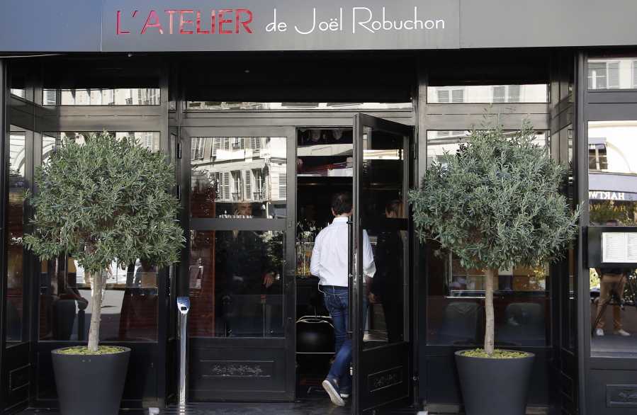 A man enters one of French chef Joel Robuchon’s restaurants Monday in Paris. Robuchon, a master chef who shook up the stuffy world of French haute cuisine by wowing palates with the delights of the simple mashed potato and giving diners a peek at the kitchen, has died.