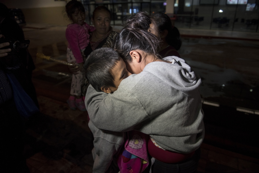 Anthony David Tovar Ortiz, left, is embraced by a relative after arriving Tuesday at La Aurora airport in Guatemala City, Guatemala. The 8-year-old stayed in a shelter for migrant children in Houston after his mother, Elsa Ortiz Enriquez, was deported in June.