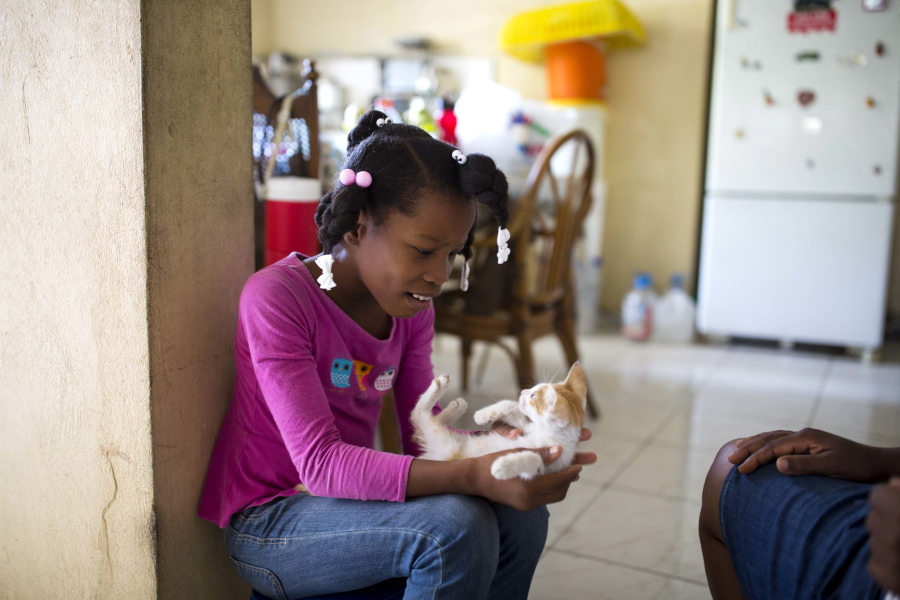Franchina 11, plays with a cat named Mima at her foster home with the Pierre family in Port-au-Prince, Haiti on Friday, June 29, 2018. Her mother dead, her father in prison, Franchina was placed in a state-run orphanage as a toddler, remaining illiterate year after year and seemingly destined for a hard life in the Western Hemisphere’s poorest nation.