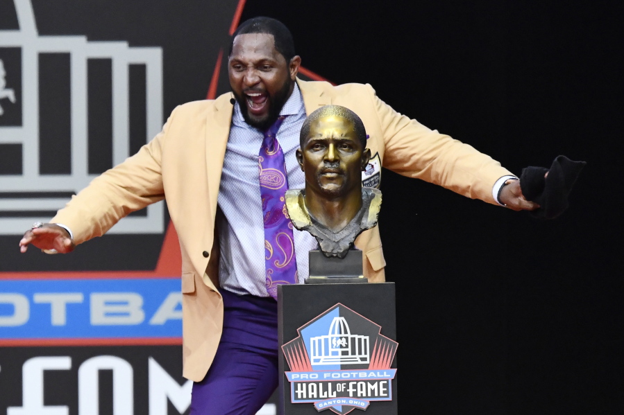 Former Baltimore Ravens linebacker Ray Lewis dances beside his bust as he delivers his induction speech at the Pro Football Hall of Fame Saturday, Aug. 4, 2018, in Canton, Ohio.