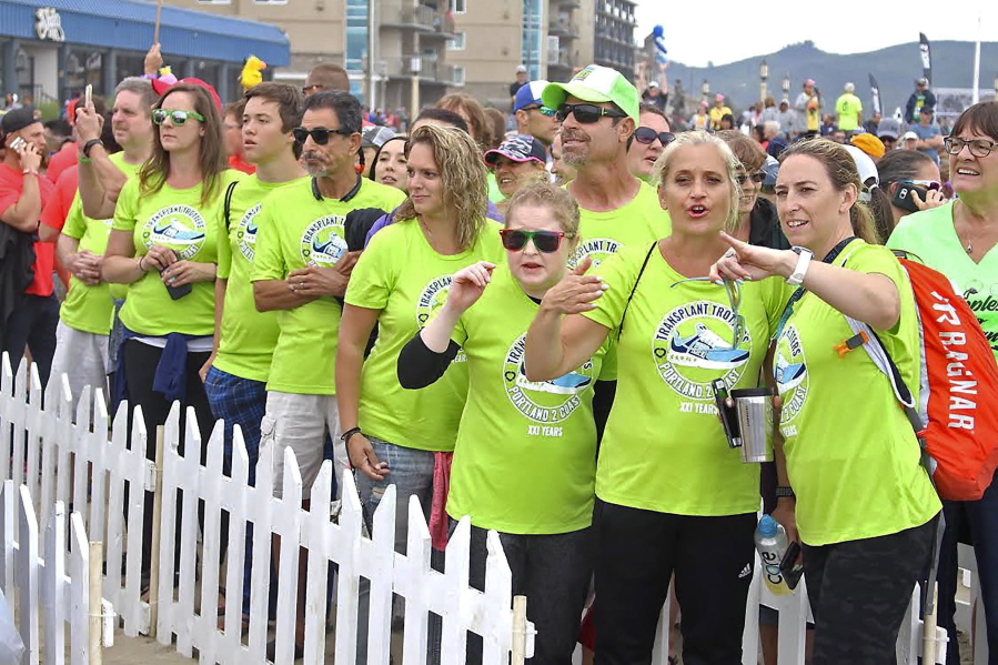 In a Saturday, Aug. 25, 2018 photo, members of the Transplant Trotters team watch for their final walker during the Hood to Coast race in Seaside, Ore.