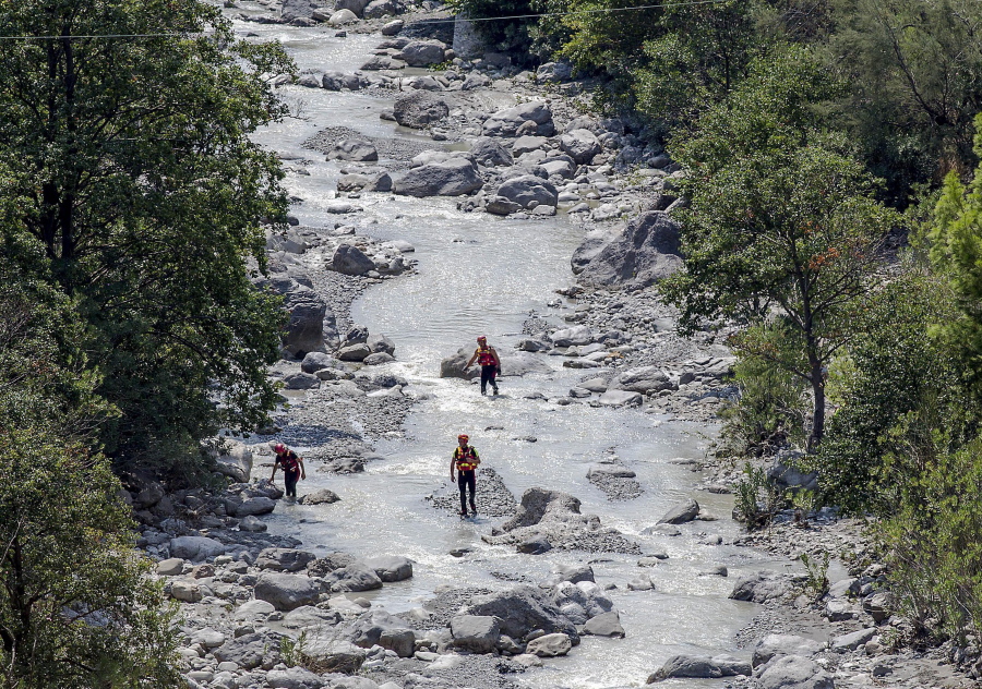 Rescuers search the Raganello Gorge area Tuesday in southern Italy after hikers were swept away by a flash flood.