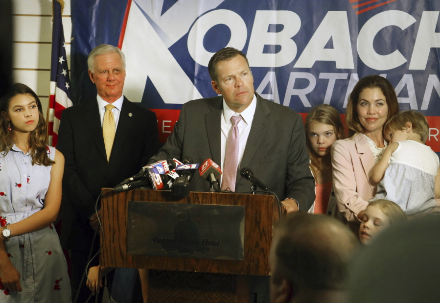 Secretary of State Kris Kobach, surrounded by his family and running mate Wink Hartman, talked to the media during a news conference at the Topeka Capitol Plaza hotel in Topeka, Kan., Wednesday, Aug. 8, 2018.