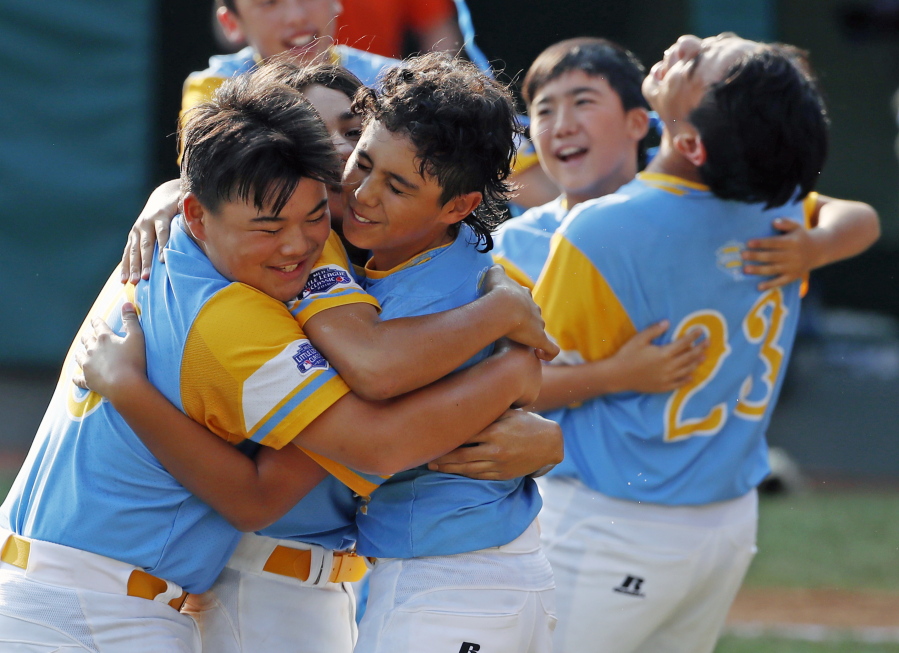 Honolulu, Hawaii pitcher Ka'olu Holt, center, begins to celebrate with Sean Yamaguchi , left, and Aukai Kea (23) after pitching a complete game, 3-0 shutout in the Little League World Series Championship baseball game against South Korea in South Williamsport, Pa., Sunday, Aug. 26, 2018. (AP Photo/Gene J. Puskar).