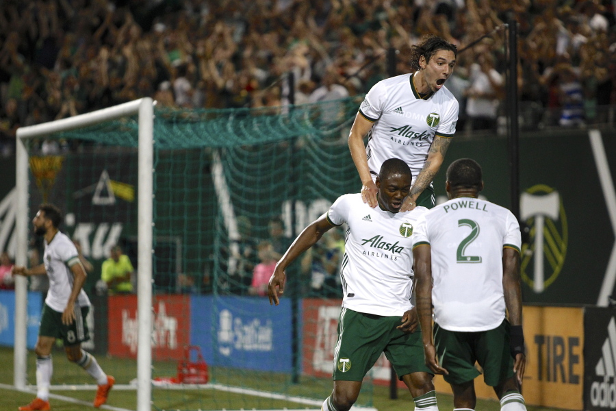 Portland Timbers’ Fanendo Adi, second from right, celebrates with teammates after scoring a goal. A fifteen-match unbeaten streak has moved the Timbers into second place in the Western Conference behind FC Dallas.