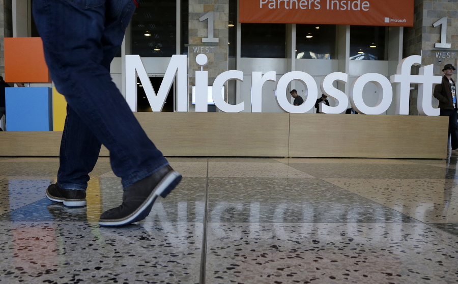 A man walks past a Microsoft sign set up for the Microsoft BUILD conference at Moscone Center in San Francisco on April 28, 2015.