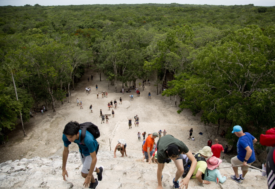 Tourists climb a temple at the archeological site of Coba, in Mexico’s Yucatan Peninsula. Whether you’re planning a trip to a country across the globe or packing for a weekend at a local campground, you can have a debt-free vacation with careful planning.