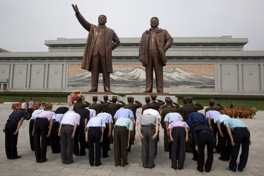 North Korean soldiers salute as others bow before the giant bronze statues of late North Korean leaders Kim Il Sung and his son Kim Jong Il during the anniversary of the end of World War II and liberation from Japanese colonial rule in Pyongyang, North Korea, on Wednesday. North Korea has marked the anniversary with a series of ceremonies ahead of what is expected to be a much bigger event next month, the 70th anniversary of its national foundation day.