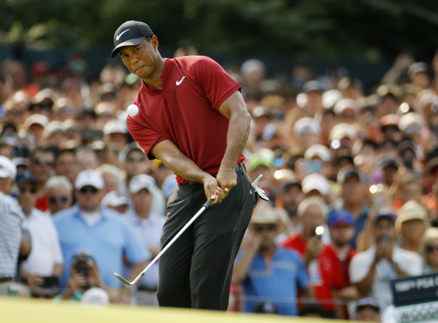Tiger Woods chips onto 14th green during the final round of the PGA Championship golf tournament at Bellerive Country Club, Sunday, Aug. 12, 2018, in St. Louis.