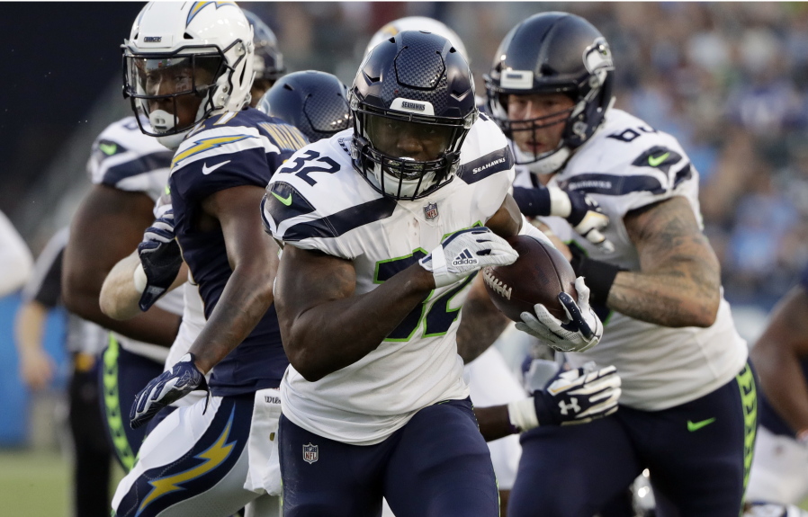 Seattle Seahawks running back Chris Carson (32) runs against the Los Angeles Chargers during the first half.