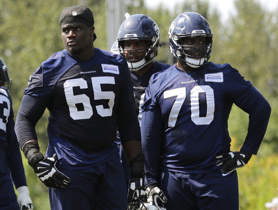 Seattle Seahawks offensive guard Germain Ifedi (65) stands on the field next to offensive guard Rees Odhiambo (70) during NFL football training camp, Monday, Aug. 6, 2018, in Renton, Wash. (AP Photo/Ted S.