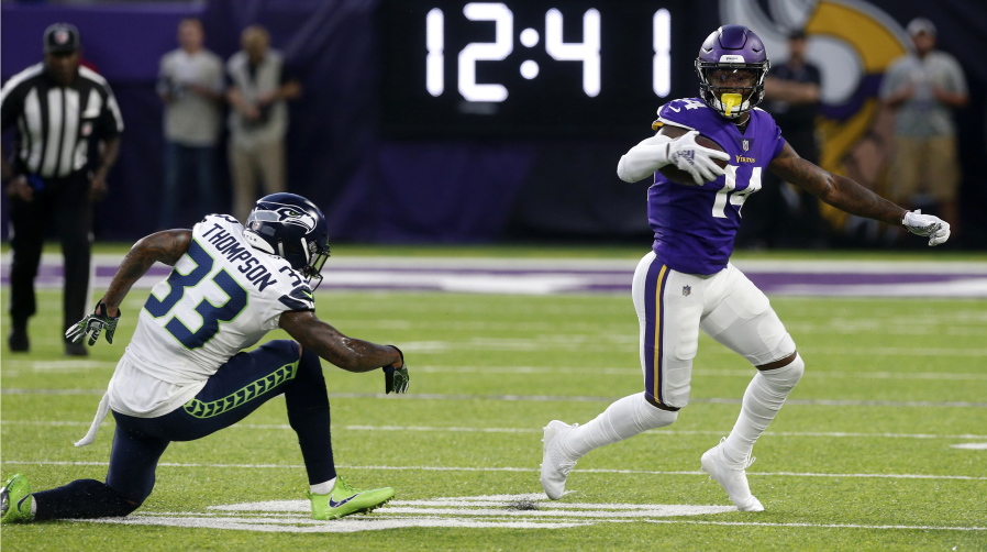 Minnesota Vikings wide receiver Stefon Diggs (14) runs from Seattle Seahawks defensive back Tedric Thompson (33) after making a reception during the first half of an NFL preseason football game, Friday, Aug. 24, 2018, in Minneapolis.