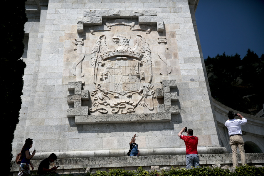 A woman makes the fascist salute as she has her picture taken in front of the eagle escutcheon of former Spanish dictator Francisco Franco’s regime July 13at the Valley of the Fallen monument near El Escorial, outside Madrid.