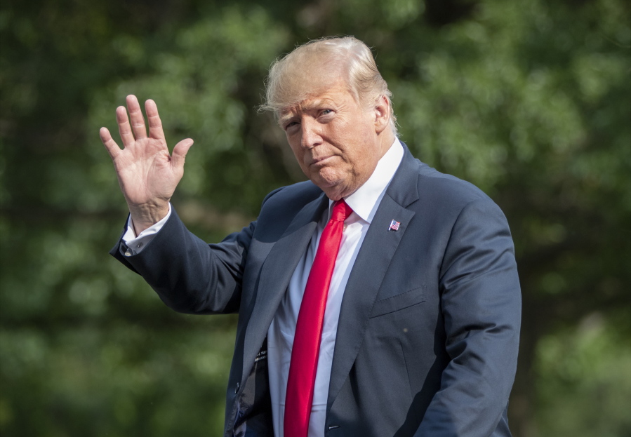 President Donald Trump waves as he arrives at the White House in Washington on Sunday after spending the weekend at his golf club in Bedminster, N.J. (AP Photo/J.